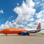 Sun Country Airlines Boeing 737-800 taking off, showcasing its livery and powerful engines.