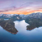 Sunset over Emerald Bay Lake Tahoe with vibrant orange and purple hues