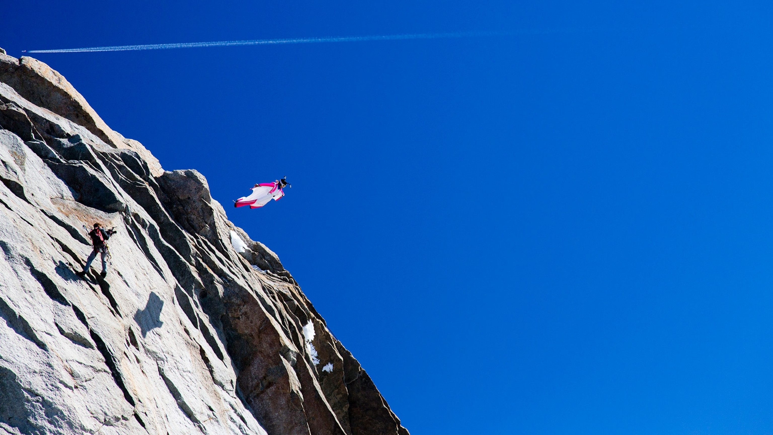 A wingsuit BASE jumper soars through the air, showcasing the skill and precision required for the sport