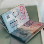Passport opened to a page filled with entry and exit stamps from various countries, representing international travel
