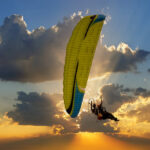 Paramotor soaring through the sky with a vibrant sunset backdrop, highlighting the freedom and adventure of the sport