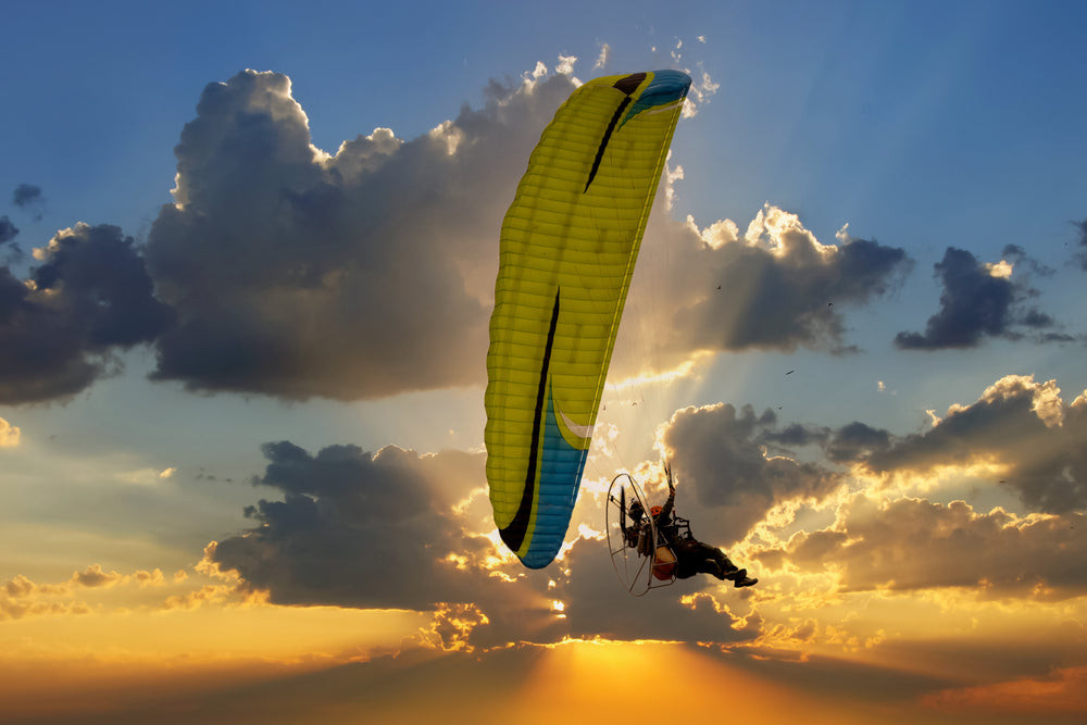 Paramotor soaring through the sky with a vibrant sunset backdrop, highlighting the freedom and adventure of the sport